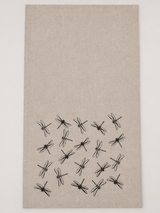 Beige tea towel with black hand printed dragonfly pattern on a white background