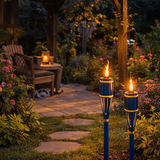 outdoor settings with blue torches illuminating garden  seating area.