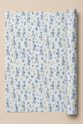 A roll of wrapping paper with a repeating pattern of Little Girls in blue dresses on a Powder Blue background, shown against a solid beige backdrop.