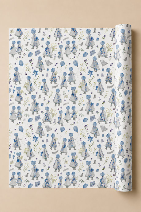 A roll of wrapping paper unrolled to show a repeating pattern of blue and gray Illustrated Water Colour girls in dresses on a white background, set against a solid beige backdrop.