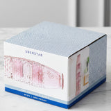 Box of Uberstar pink drinking glasses on a kitchen side