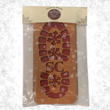 Pair of wooden Santa boot footprint stencils in Byard’s Boutique Christmas packaging, with snowflake tread and SC cut-outs.