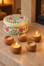 Five little terracotta candles and a hand-painted tin to keep. This candle gift set combines lavender with a subtle hint of vanilla, with approximately three hours of burn time per candle. Once emptied, the white stainless steel container can hold biscuits or small keepsakes.