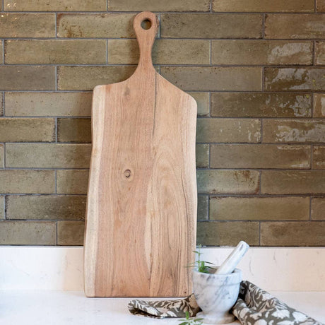 Wooden cutting board against a brick wall
