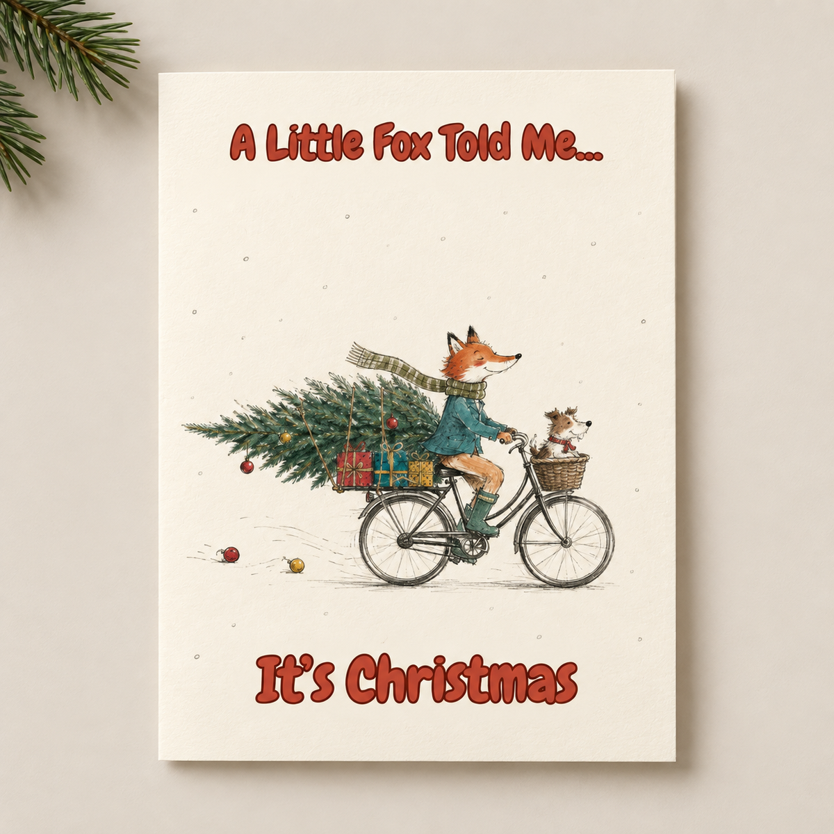 A rectangular Christmas greeting card or print with an illustrated fox riding a bicycle with a Christmas tree and presents, bordered by pine branches at the top left. The text reads “A Little Fox Told Me.