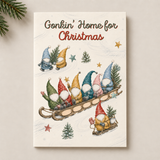 A Christmas-themed art print or card featuring the text 'Gonkin' Home for Christmas' above a whimsical illustration of gnome characters in sleds, displayed against a light beige background with pine branches in the corner.