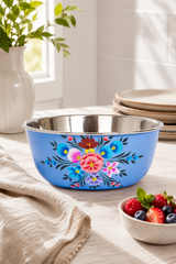 Blue floral-patterned bowl on a table with a stack of plates and a bowl of berries in the background.