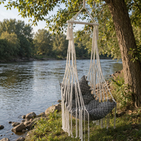 Hanging chair with patterned cushion by a river and trees