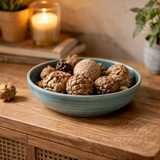 A blue ceramic bowl containing various items on a wooden surface.