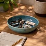 a blue ceramic bowl containing various items on a wooden surface.