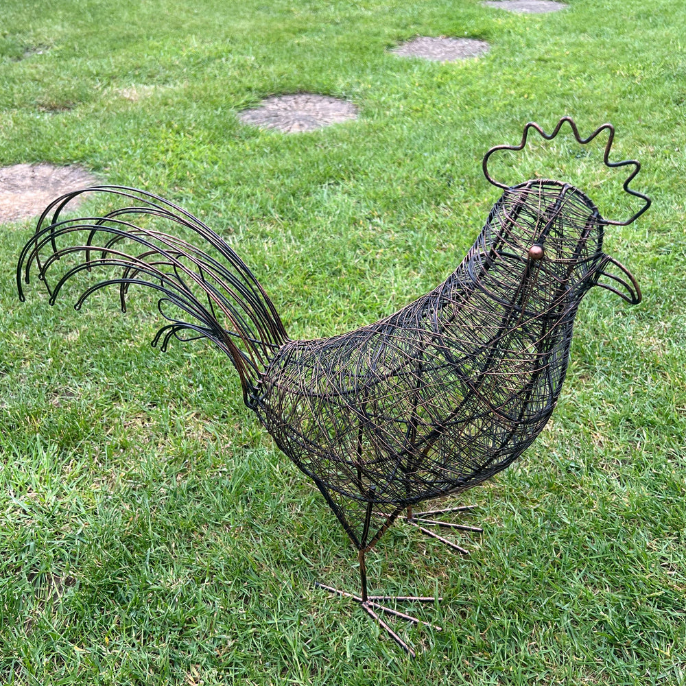 Decorative wire rooster sculpture on a grassy lawn