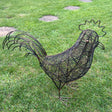 Decorative wire rooster sculpture on a grassy lawn