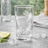 Clear glass with dragonfly design on a table with lime and ice cubes