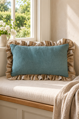 Rectangular duck egg linen cushion with natural ruffled edging on an ivory cottage window seat.