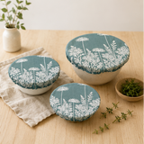 A set of three reusable Duck Egg Green Florilegium linen bowl covers, hand printed in Derbyshire with a delicate white botanical design featuring agapanthus and foxglove flowers.