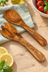 Olive wood salad spoon and fork engraved with “Emma’s Kitchen” and “Made with love”, styled with sage linen, tomatoes and lemon.