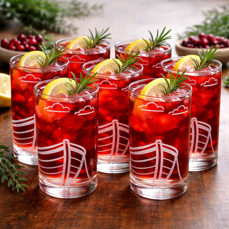 Set of 6 boat etched design glasses filled with red beverage, lemon slices, and rosemary sprigs on a wooden surface.
