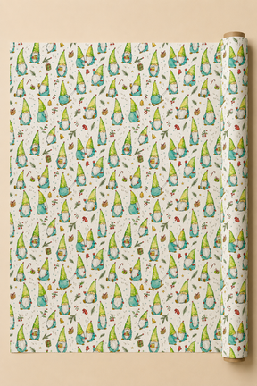 A roll of wrapping paper with a repeating pattern of cute green and blue gnomes on a cream background, displayed flat with the roll standing on the right side against a warm beige backdrop.
