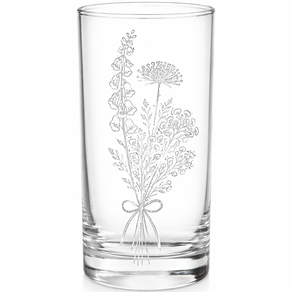 Clear glass tumbler with floral engraving on a white background