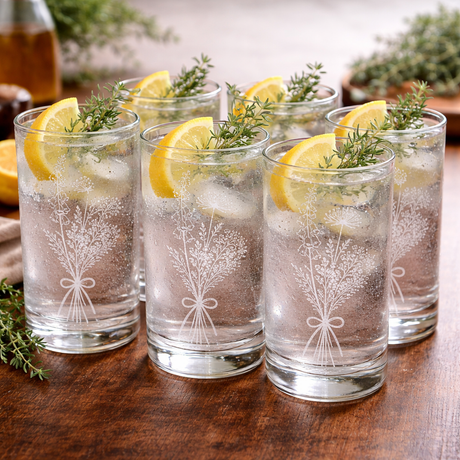 Set of six glasses with lemon slices and ice on a wooden surface