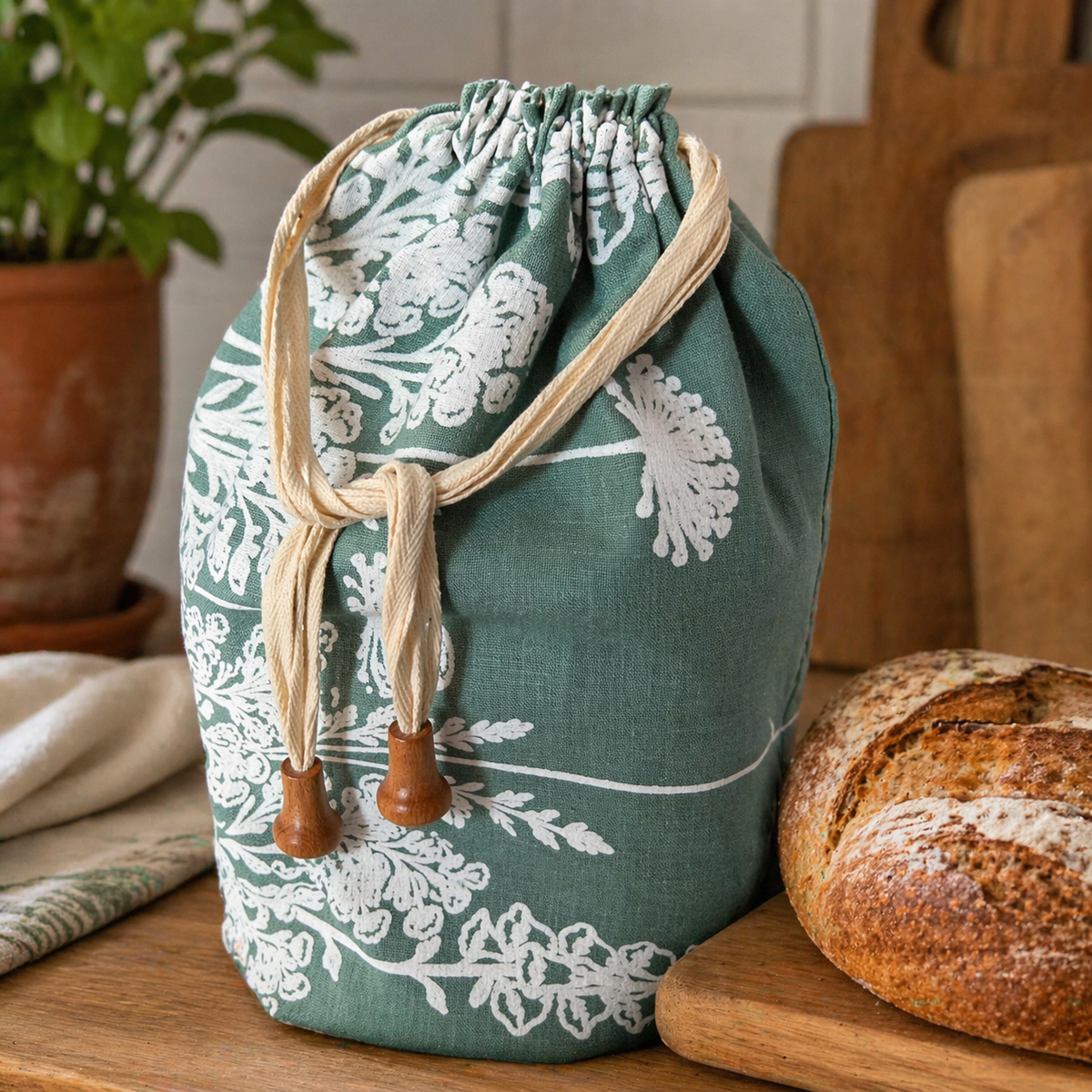 Sage green Florilegium linen bread bag with a white botanical print.
