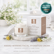 Facial hydration cream with packaging on a marble surface with flowers, featuring an award badge.