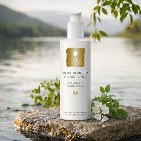 Geranium & Ylang Ylang Keratin Silken Conditioner on rock by a lake 