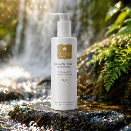 Geranium & Ylang Ylang Keratin Silken Shampoo with natural setting lakes and plants.