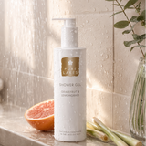 shower gel bottle with a bathroom setting, including a shower and grapefruit.