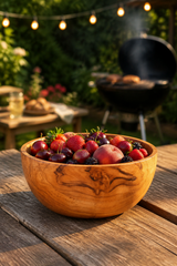 Hand-Turned Wooden Snack & Serving Bowl – 16cm filled with fresh strawberries, plums, and blackberries sits on a rustic wooden table in an outdoor backyard setting with a grill and string lights blurred in the background.