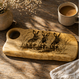 Hand made charcuterie board with rabbit design on a table setting with food.