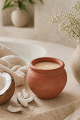 Terracotta pot candle with coconut on the side of a bath