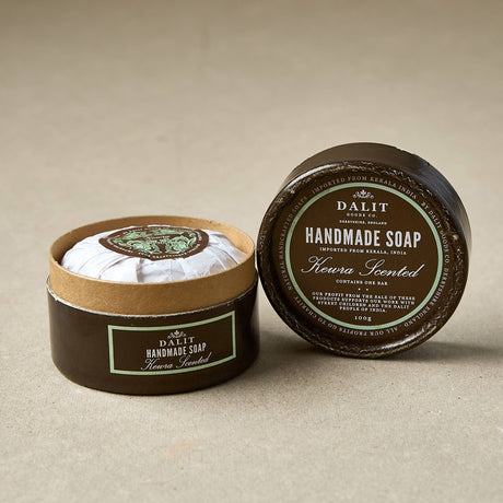 Handmade soap Keira scented in a round container with a label on a beige background