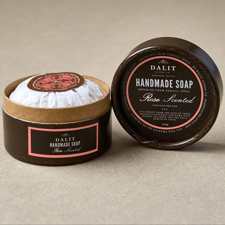 Handmade soap Rose scented in a round container with a black lid on a beige background