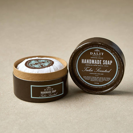 Handmade soap tulsi scented in a brown container with a visible label on a beige background