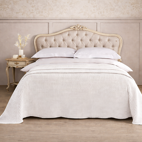 Neatly made bed with white bedding in a bedroom setting