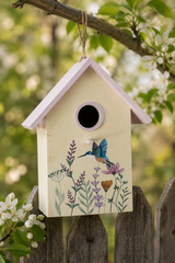 Decorative birdhouse with floral designs and a bird illustration hanging on a branch.