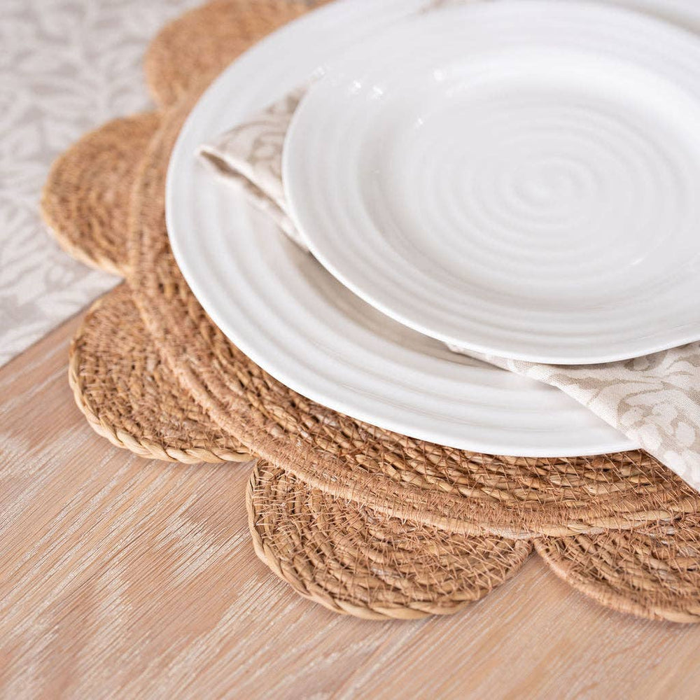 White ceramic plates on woven placemats on a wooden table