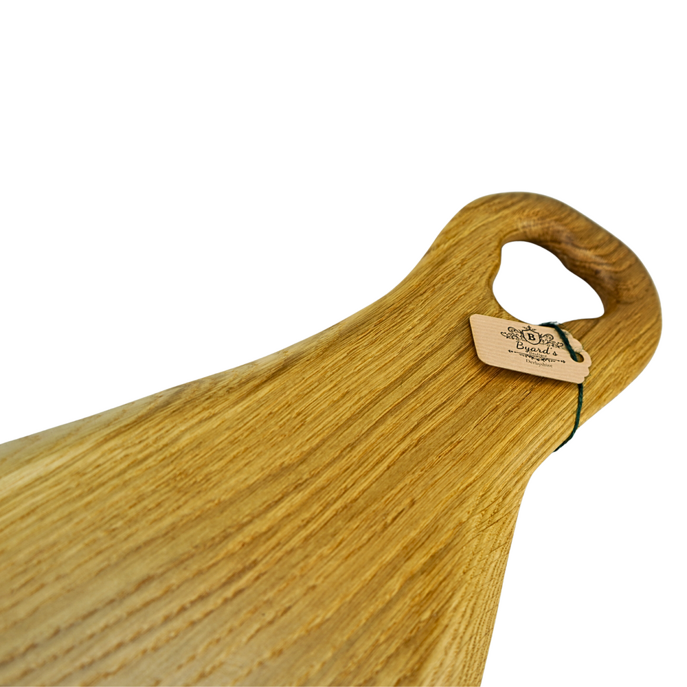 “Large handmade oak charcuterie board with a natural waney edge and detailed wooden handle.”