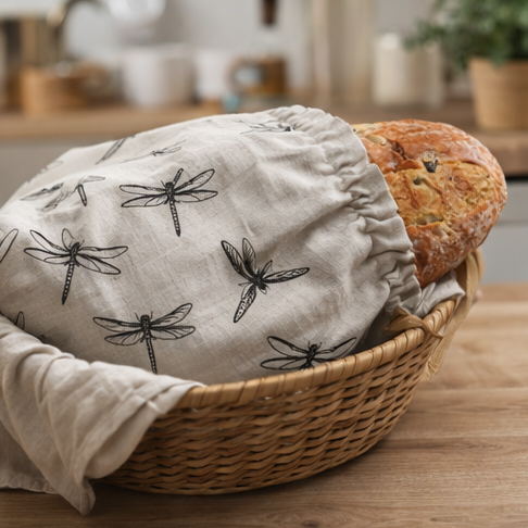 Fabric bread bags with dragonfly pattern used for storing bread in a kitchen setting.