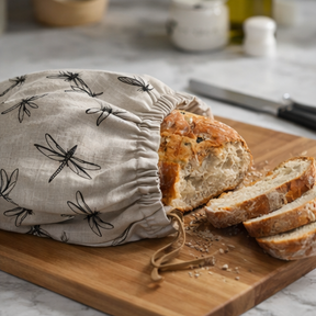 Fabric bread bags with dragonfly pattern used for storing bread in a kitchen setting.