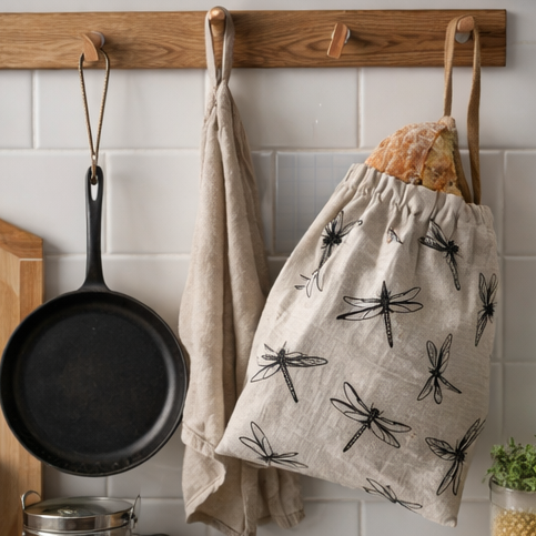Fabric bread bags with dragonfly pattern used for storing bread in a kitchen setting.