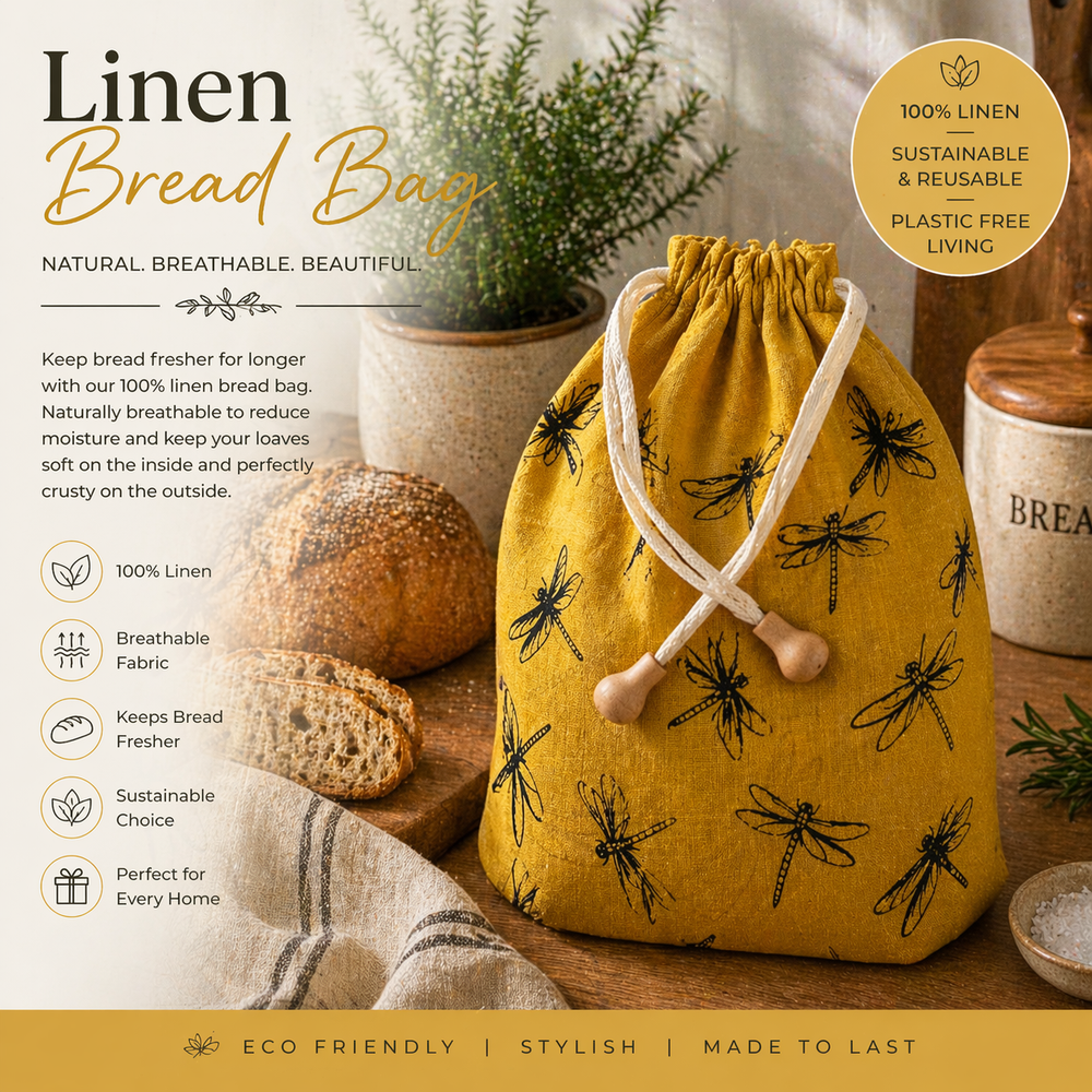 Yellow linen bread bag with dragonfly pattern on a wooden surface with bread and plants.