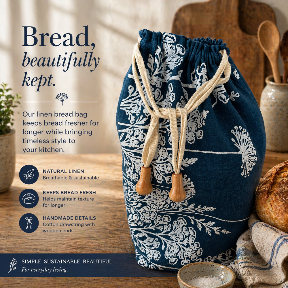 Navy blue linen bread bag with white floral patterns on a wooden surface, with text describing its features.