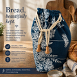 Navy blue linen bread bag with white floral patterns on a wooden surface, with text describing its features.