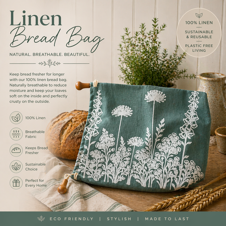Linen bread bag with floral design on a wooden surface, accompanied by bread and plants.