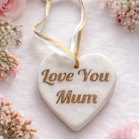 Heart-shaped Marble ornament with 'Love You Mum' text, surrounded by pink flowers on a light background