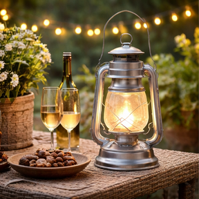 Metal Paraffin Hurricane Lantern on outside table with two glasses of wine