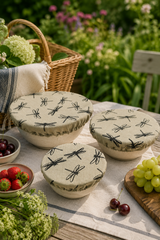 Set of three Natural Dragonfly linen reusable bowl covers with a black dragonfly print, hand printed in Derbyshire and lined with food-safe waterproof fabric. The set includes small, medium and large covers for bowls from approximately 12cm to 30cm diameter.