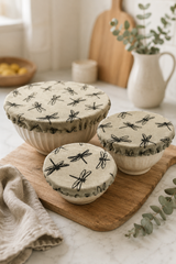 Set of three Natural Dragonfly linen reusable bowl covers with a black dragonfly print, hand printed in Derbyshire and lined with food-safe waterproof fabric. The set includes small, medium and large covers for bowls from approximately 12cm to 30cm diameter.